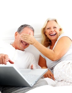 Couple Laughing While Reading in Bed